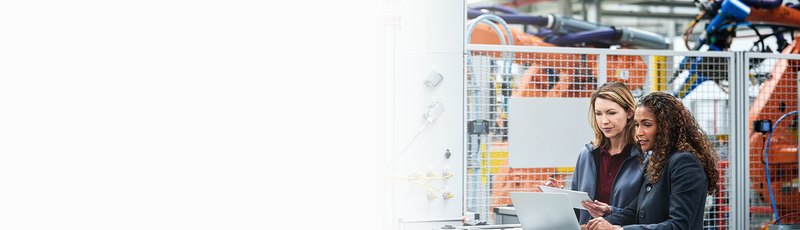 Two manufacturing staff examine data on a device