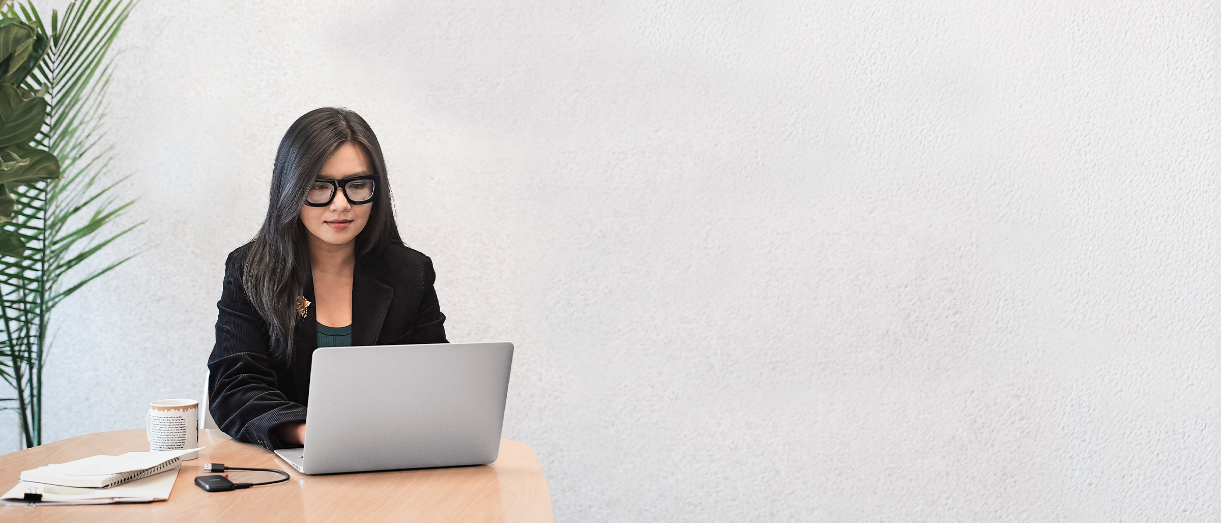 Person in an office setting, typing while viewing a desktop monitor