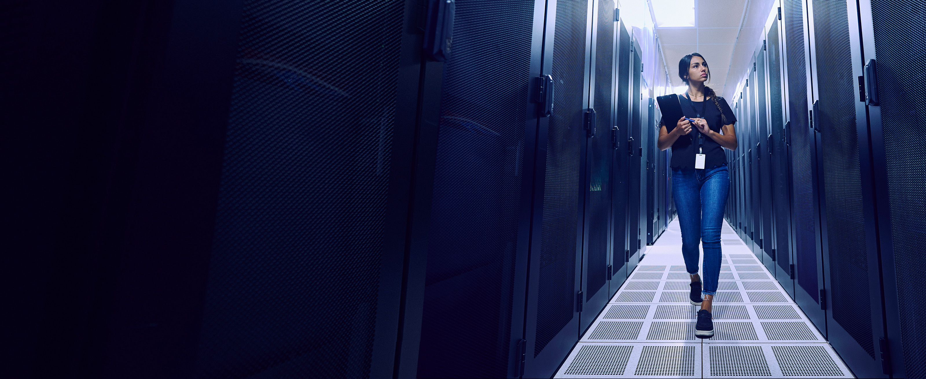 IT worker with clipboard walking through enterprise server room